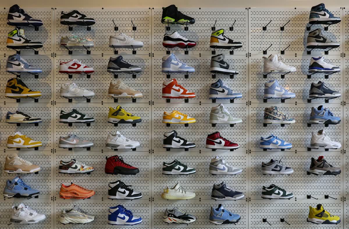 A wall of sneakers displayed in rows on pegboard shelving